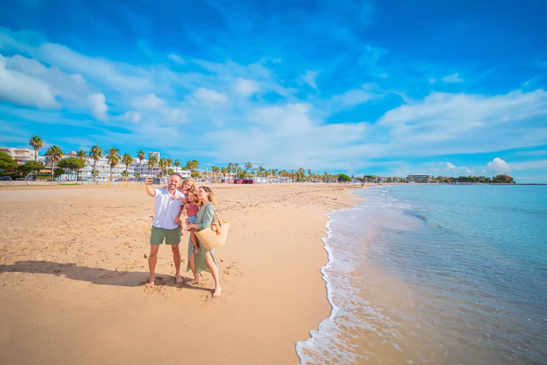 Una família passeja per la platja de Cambrils